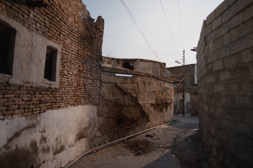 an alley way with a brick wall and a broken window