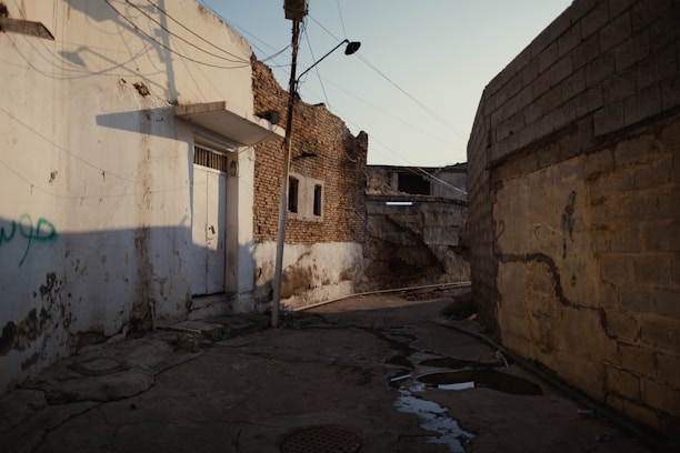 an alley way with a building and a street light