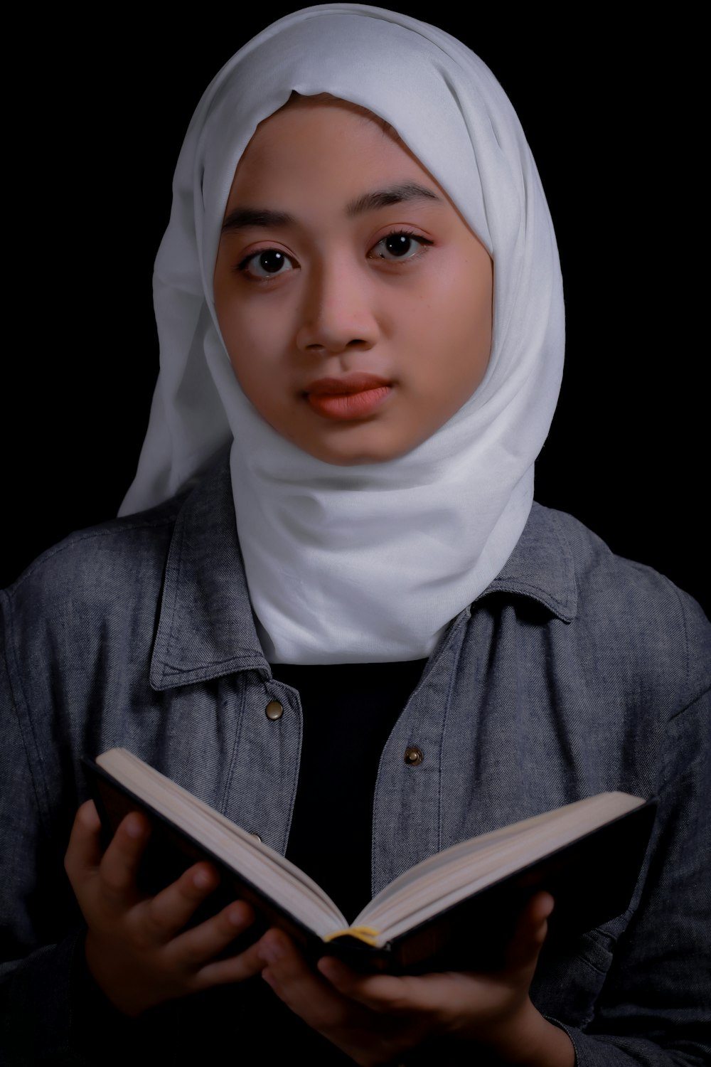 a woman in a hijab reading a book