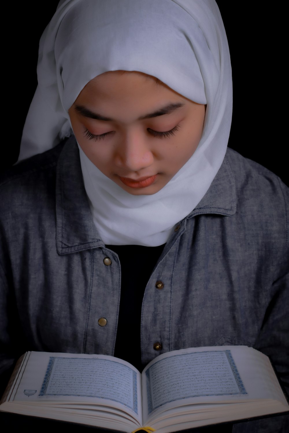 a woman in a hijab reading a book