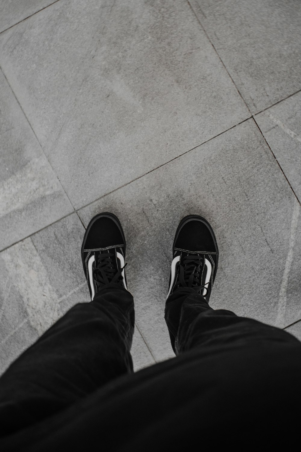 a pair of feet standing on a sidewalk
