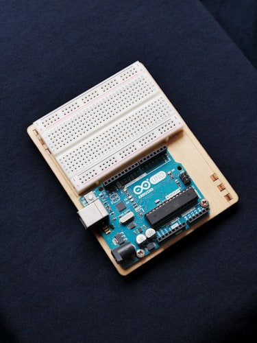 Arduino microcontroller board with jumper wires connected for MicroVGA testing on breadboard