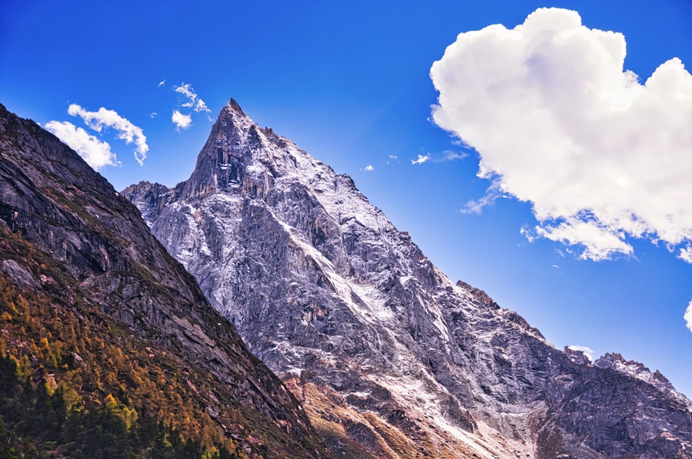 a very tall mountain with some clouds in the sky