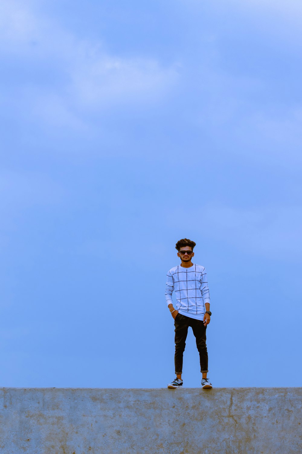 a man standing on top of a cement wall