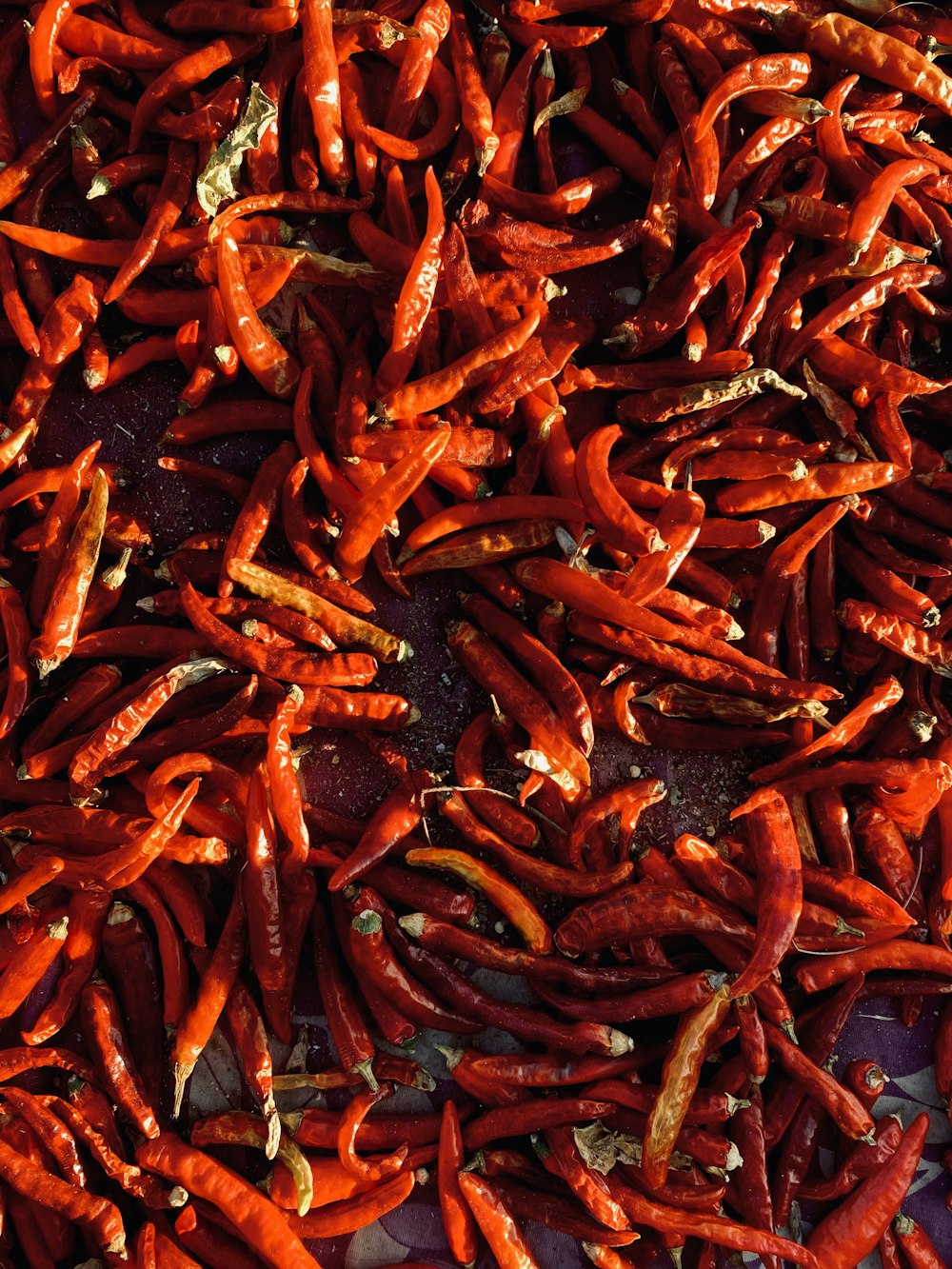 a pile of red peppers sitting on top of a table