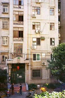A group of neighbors discussing building maintenance outside their apartment complex.