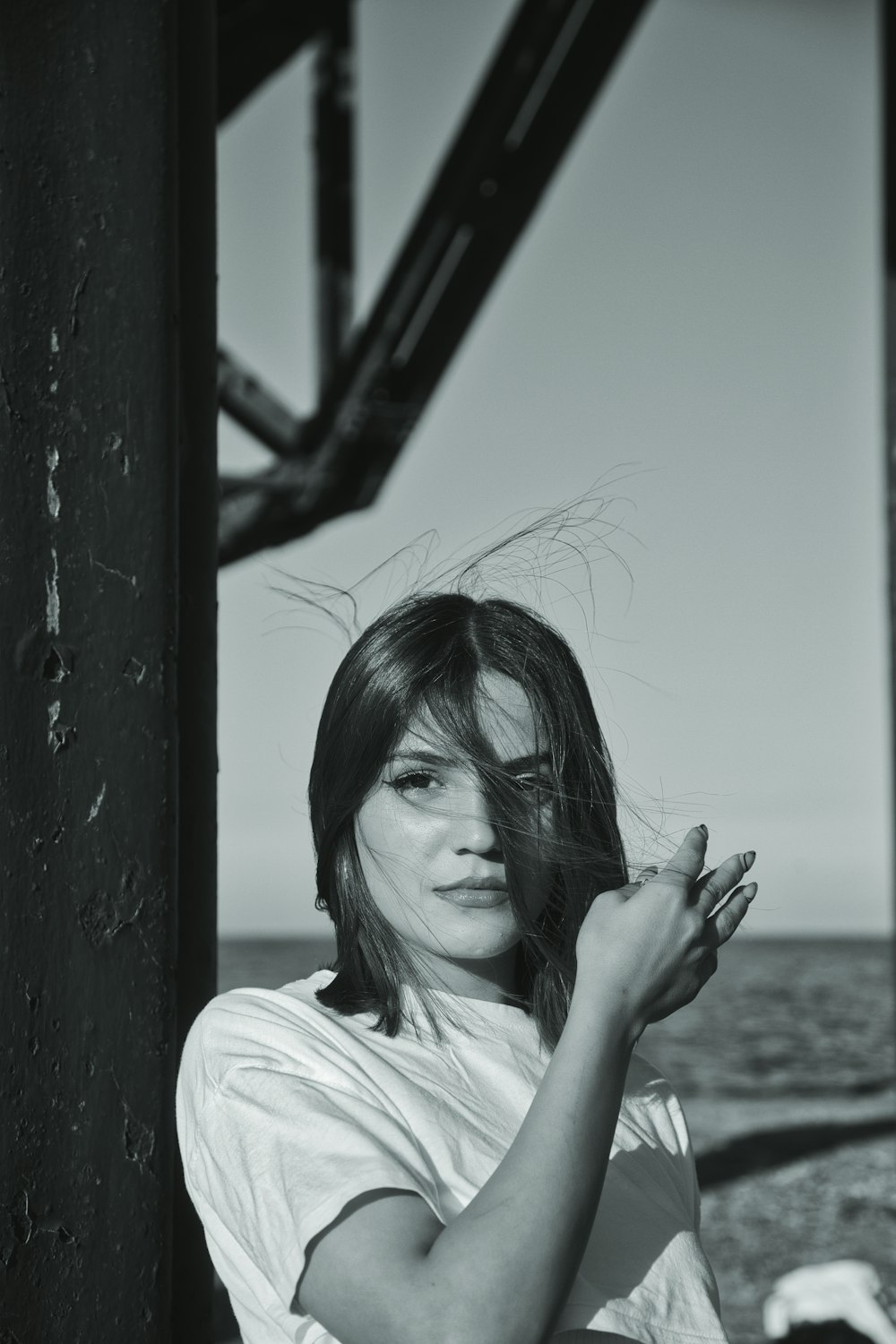 a black and white photo of a woman holding her hair