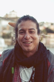 A happy person listening to music with headphones, smiling warmly.