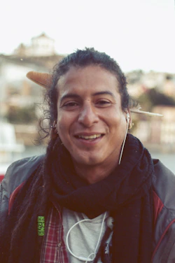 A warm, candid photo of Silvan smiling while listening to music with headphones.