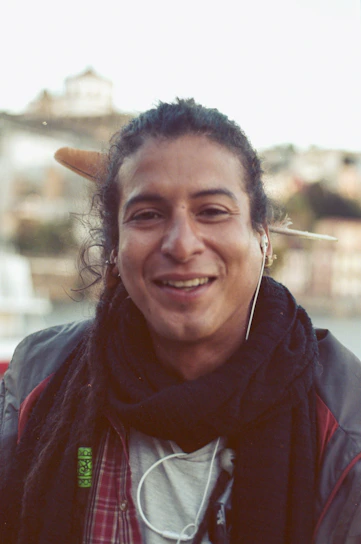 A warm, candid photo of Silvan smiling while listening to music with headphones.