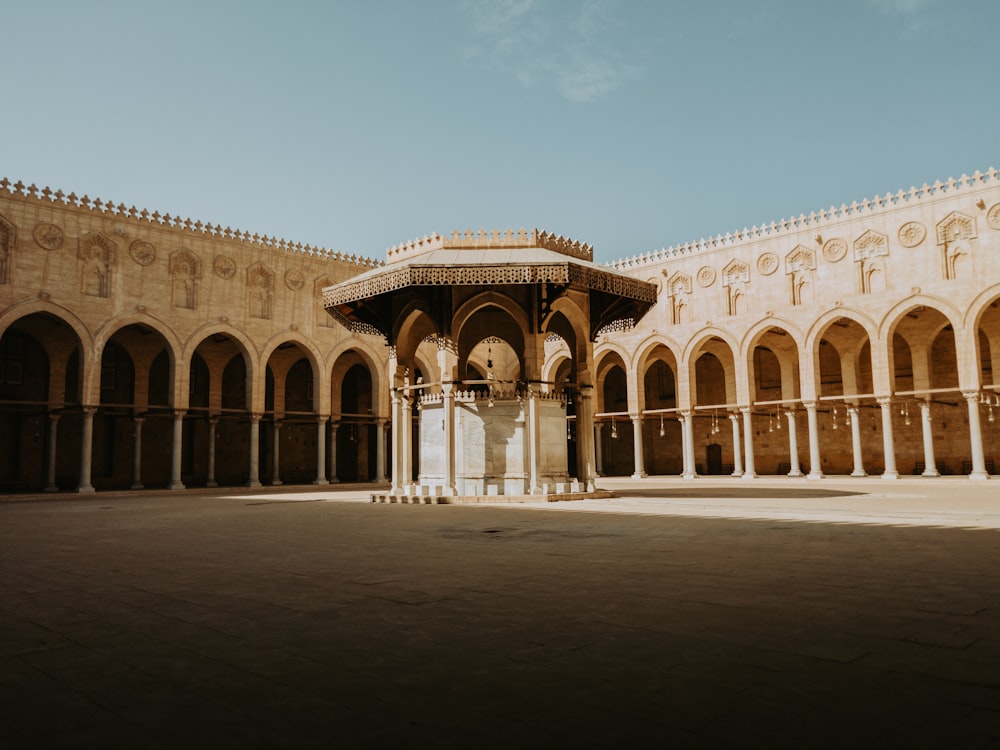 a courtyard with arches and a clock tower