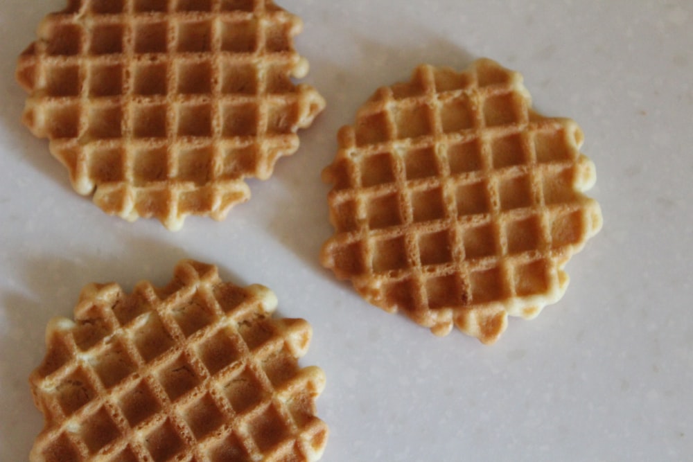 three waffles sitting on a white counter top