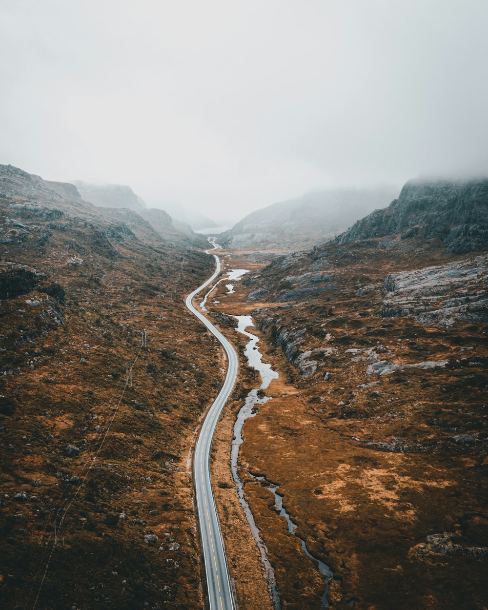 a winding road in the mountains on a foggy day