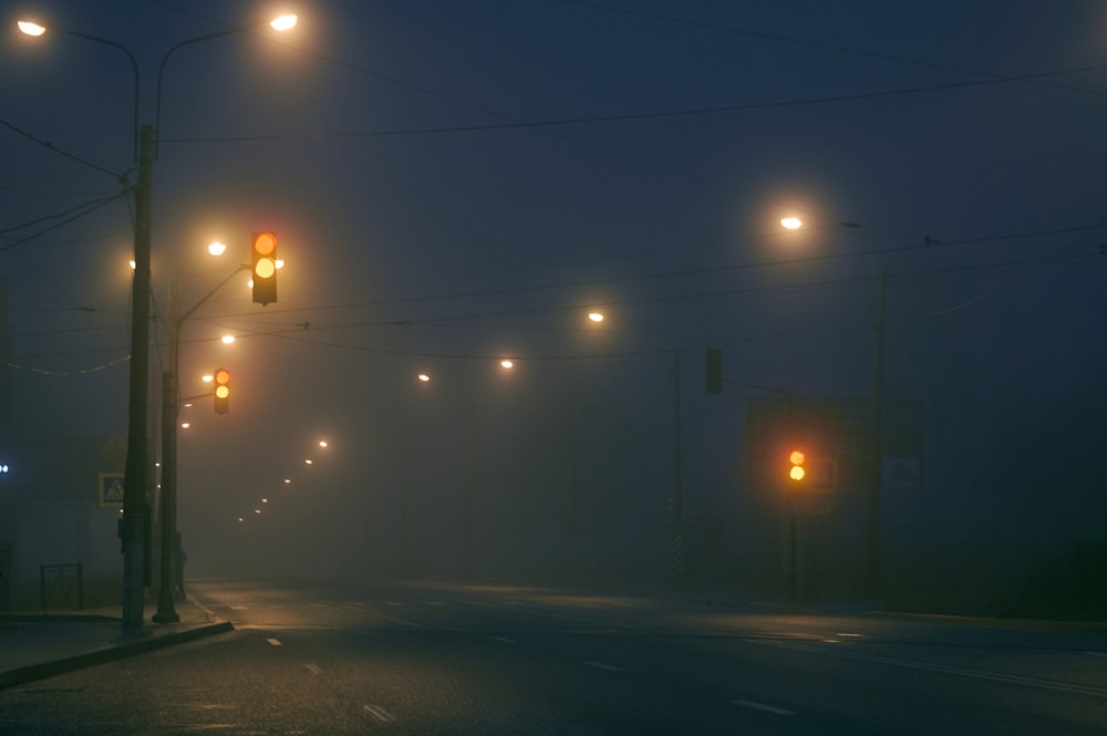 a foggy street at night with street lights