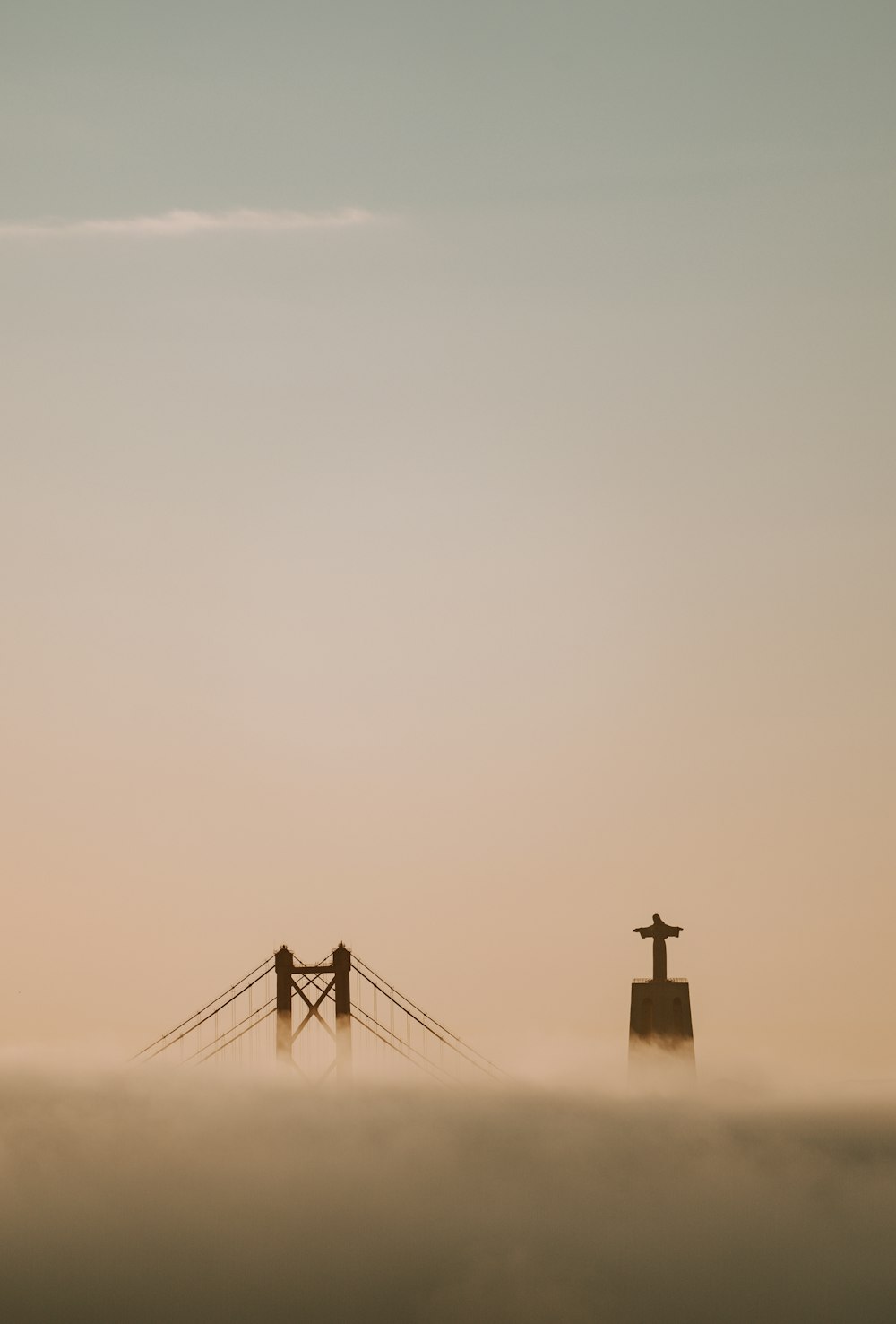 a foggy landscape with a bridge in the distance