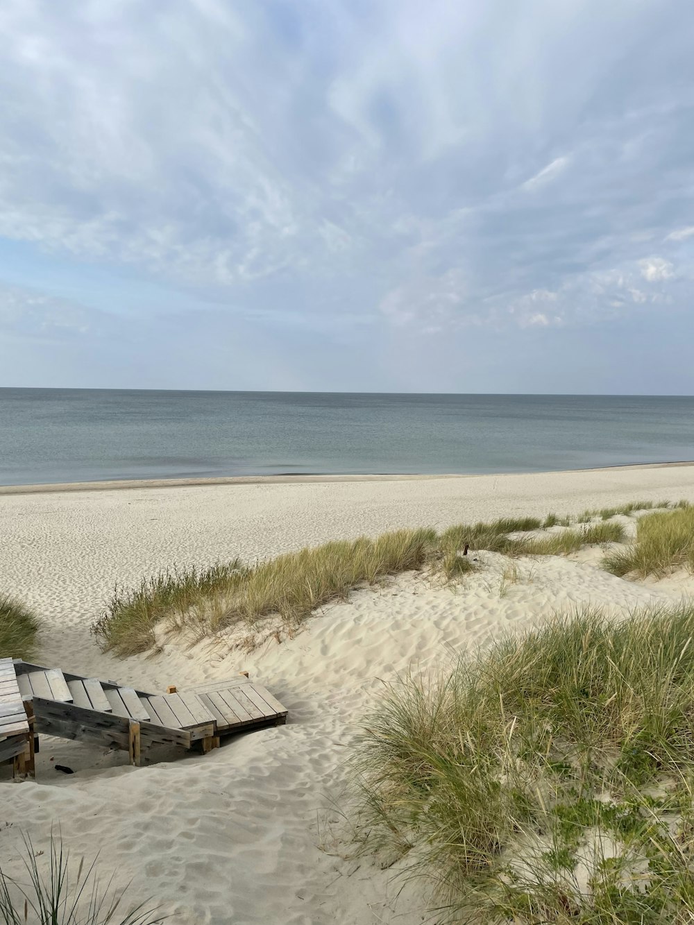 a sandy beach with a few chairs on it