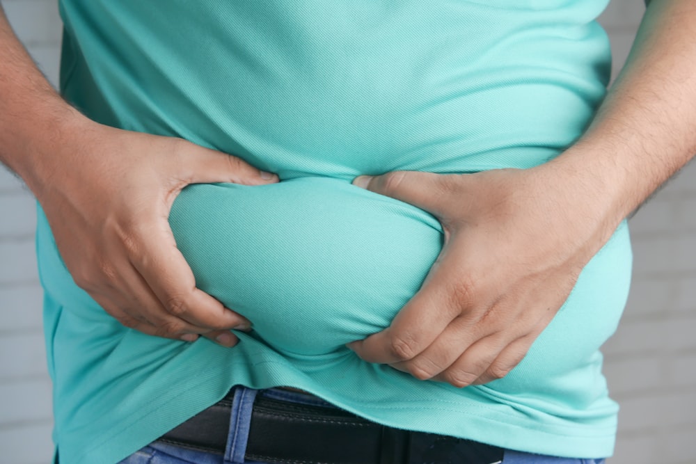 a man holding his stomach with his hands