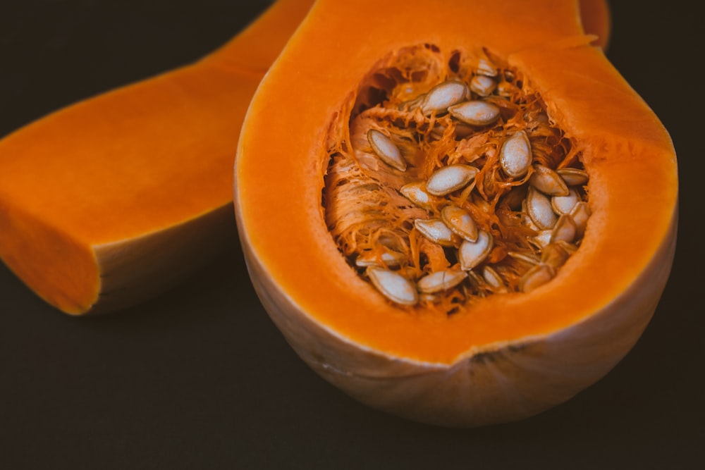 a close up of a pumpkin with seeds inside of it