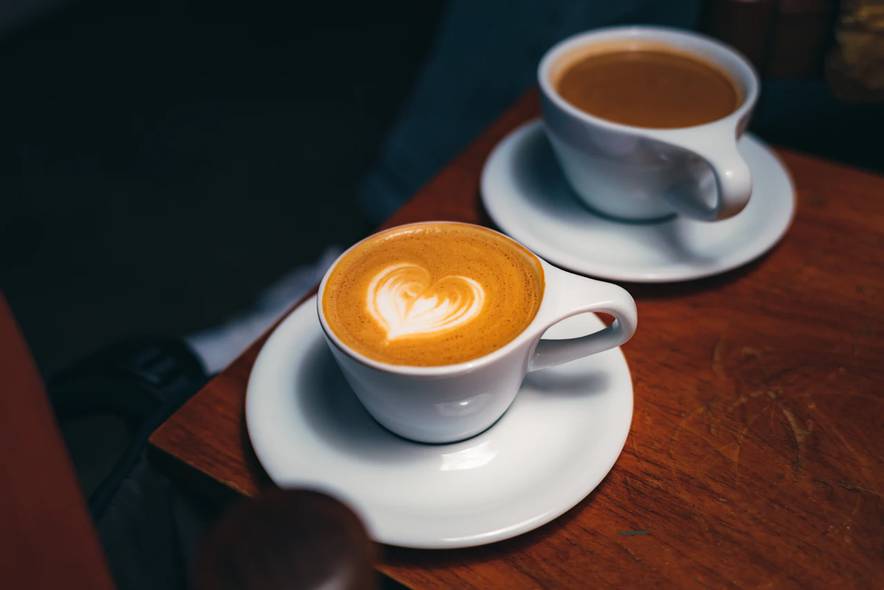 Two cups of coffee on a wooden cafe table