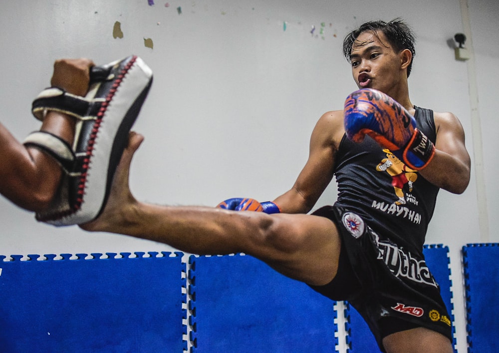 a man kicking a ball in a gym