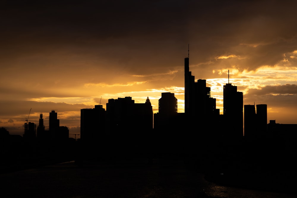 the sun is setting over a city with tall buildings