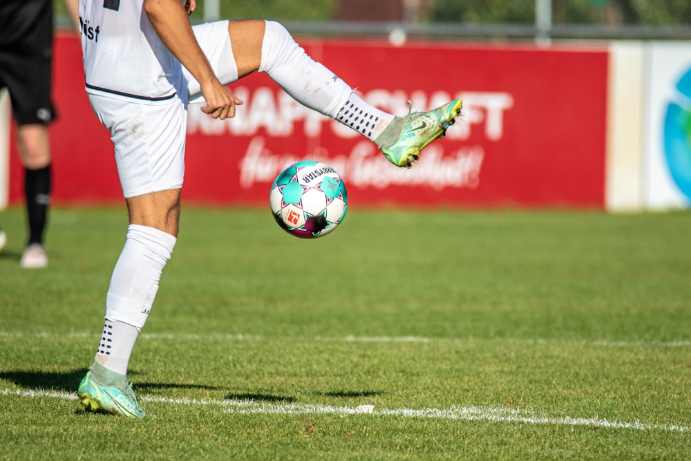 a man kicking a soccer ball on a field