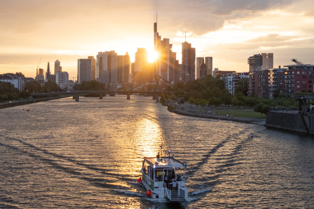 a boat traveling down a river with a city in the background