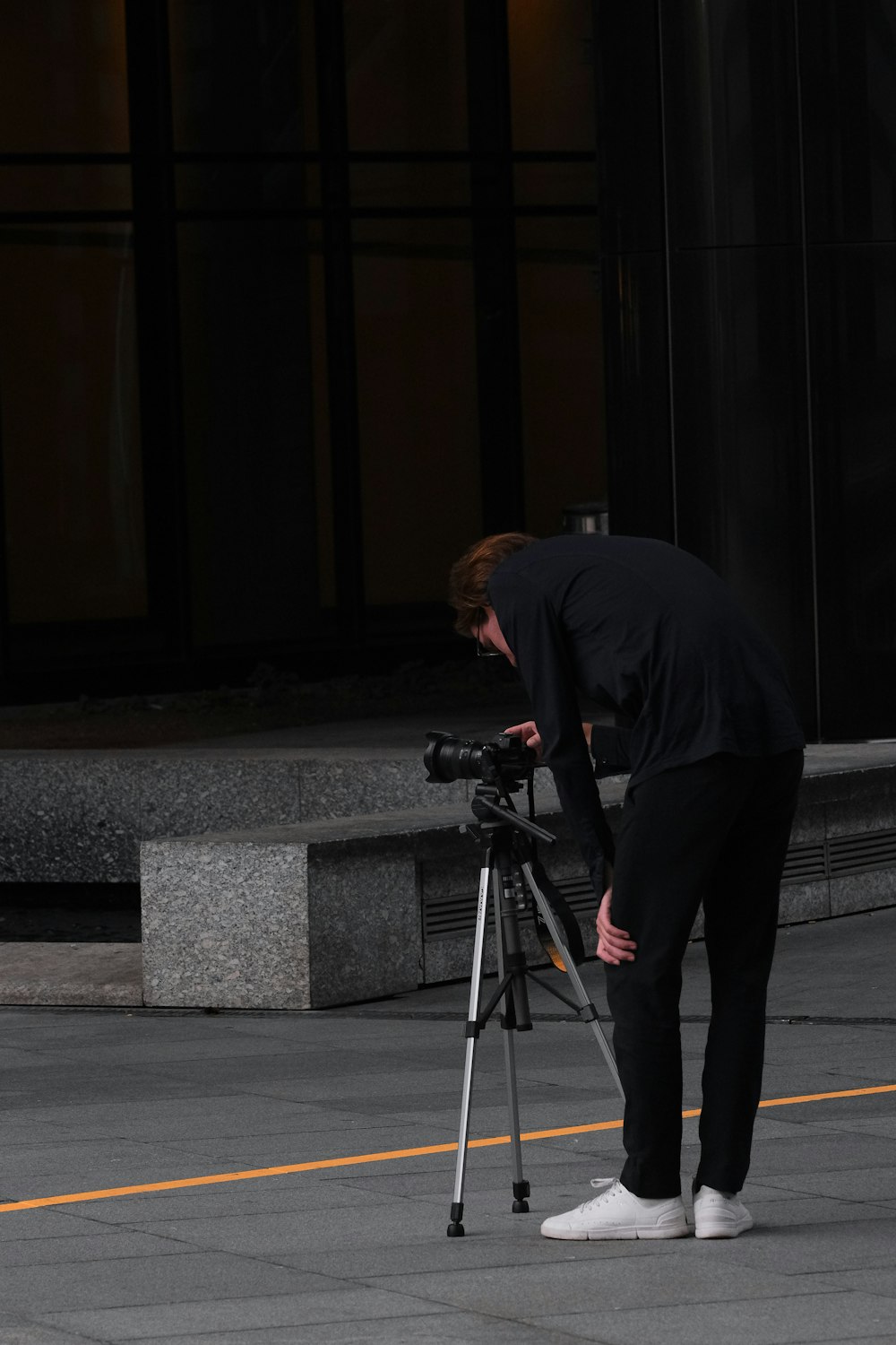 Un uomo in camicia nera sta guardando una telecamera