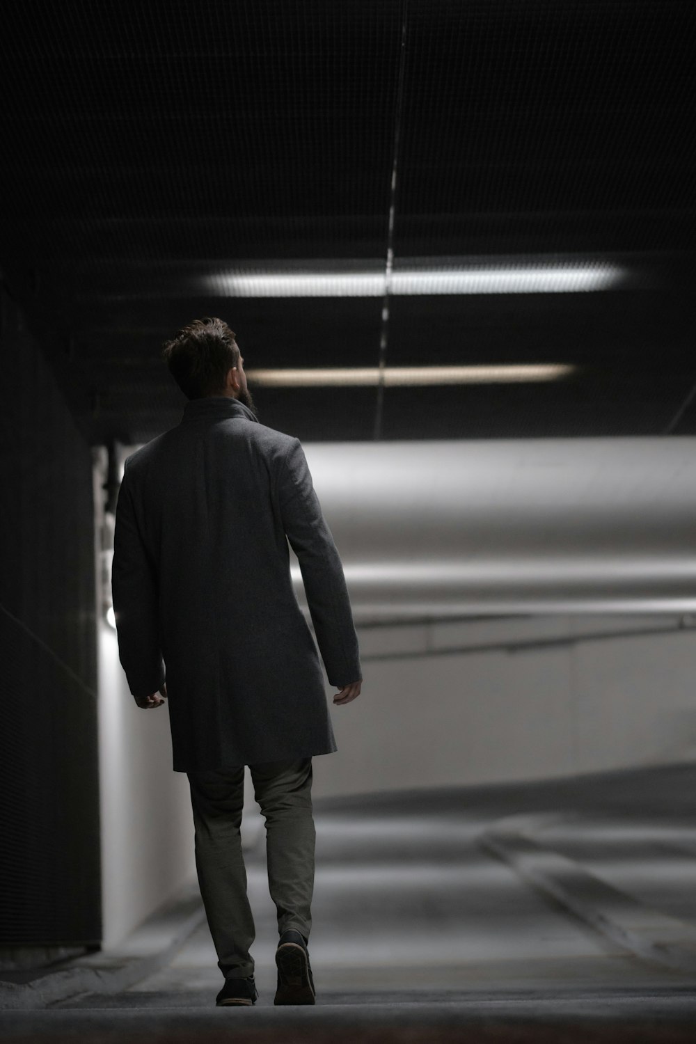 a man is walking down a dark tunnel
