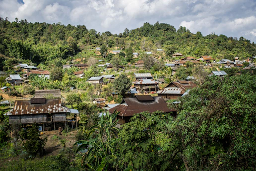 a village nestled on a hill surrounded by trees