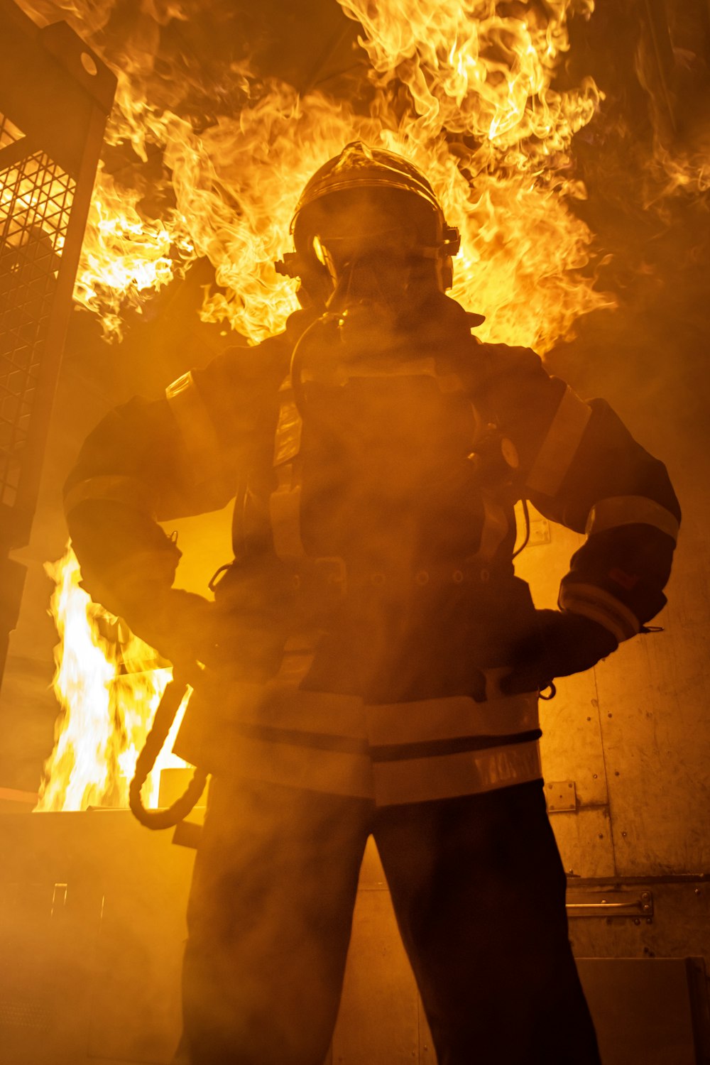 Ein Feuerwehrmann steht vor einem großen Feuer