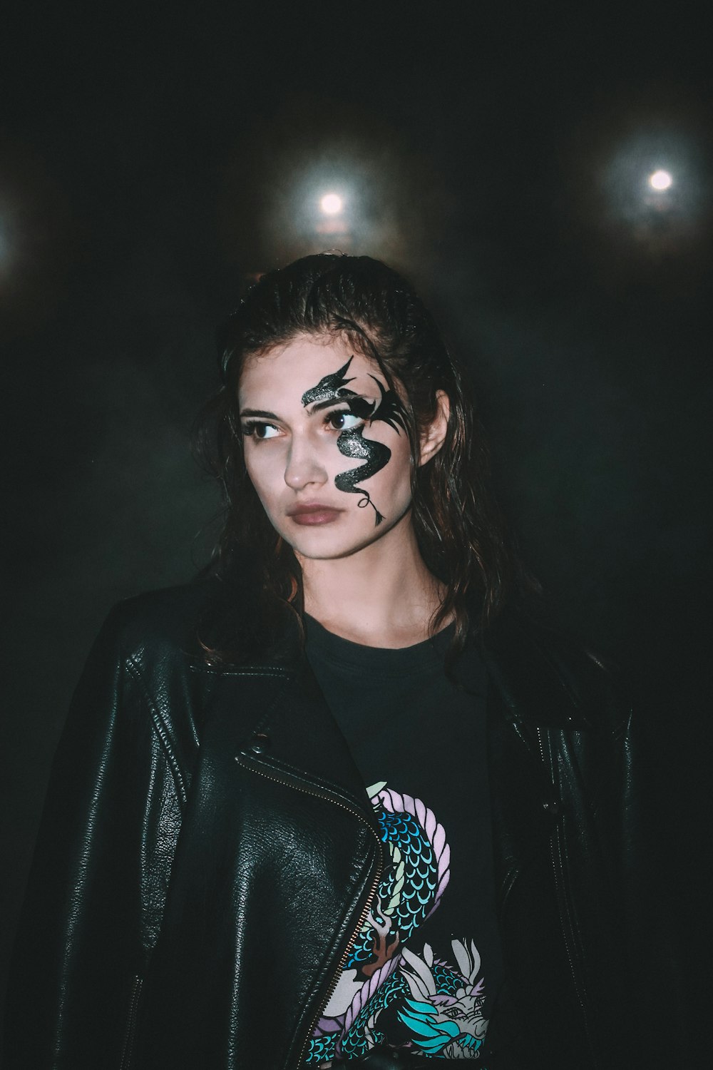 a woman with black and white face paint on her face