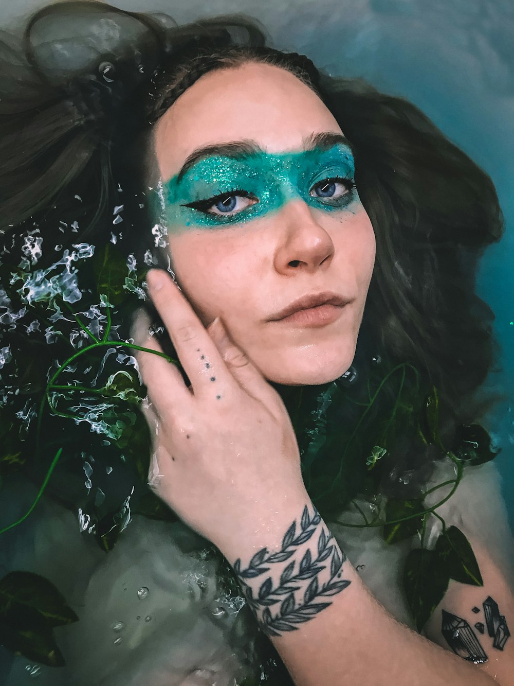 a woman with green makeup in the water