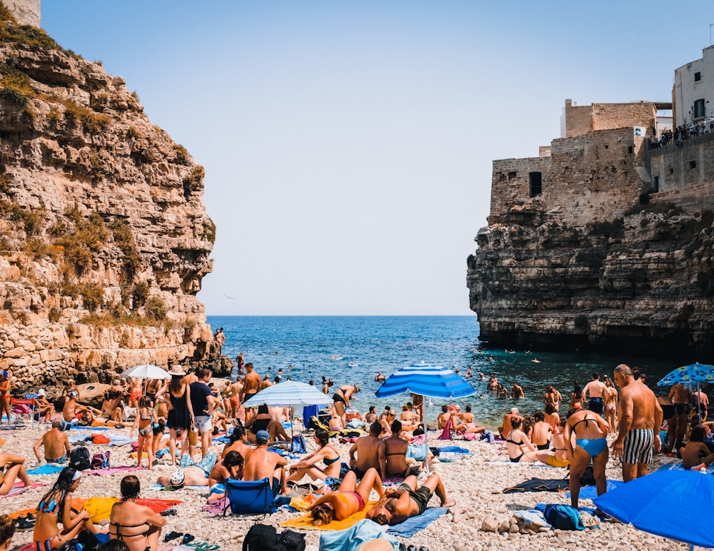 a group of people sitting on top of a sandy beach