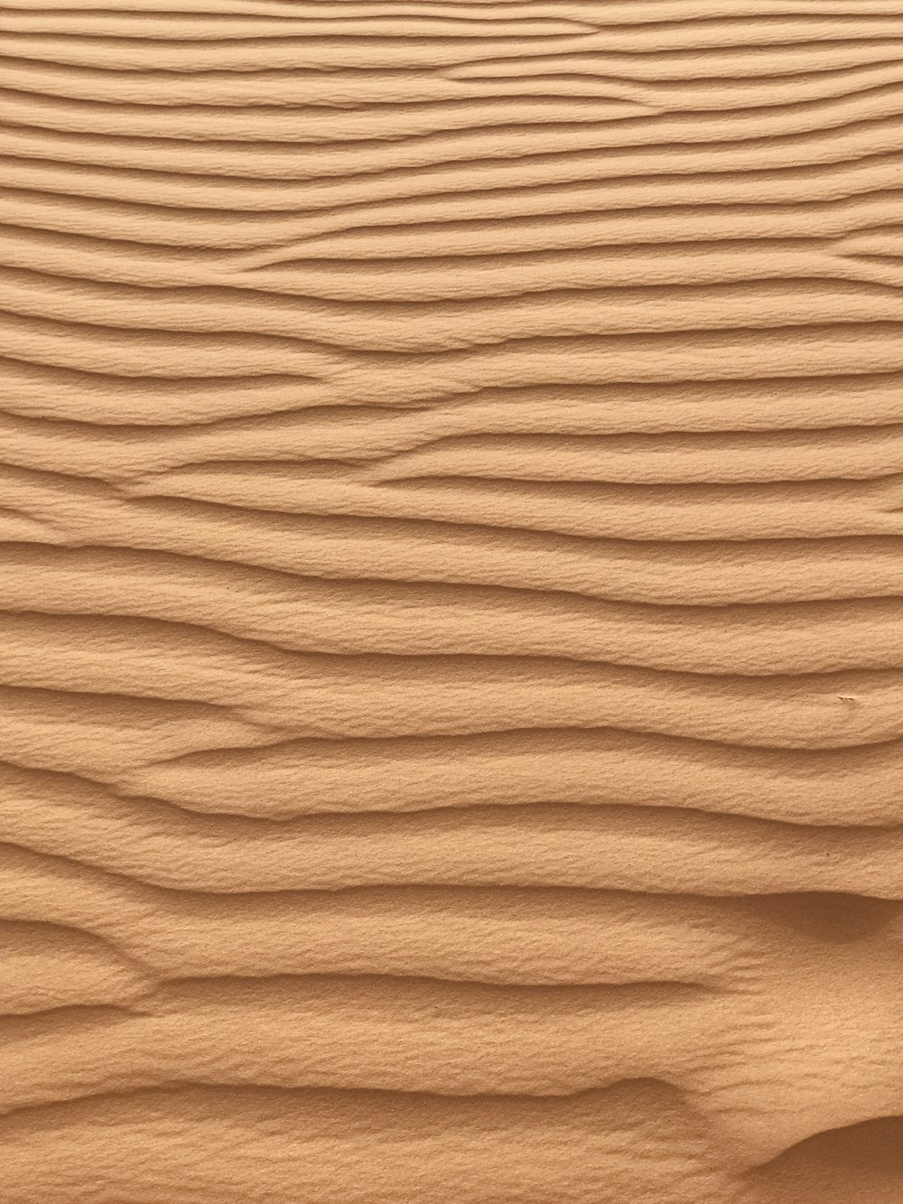 a sand dune with wavy lines in the sand