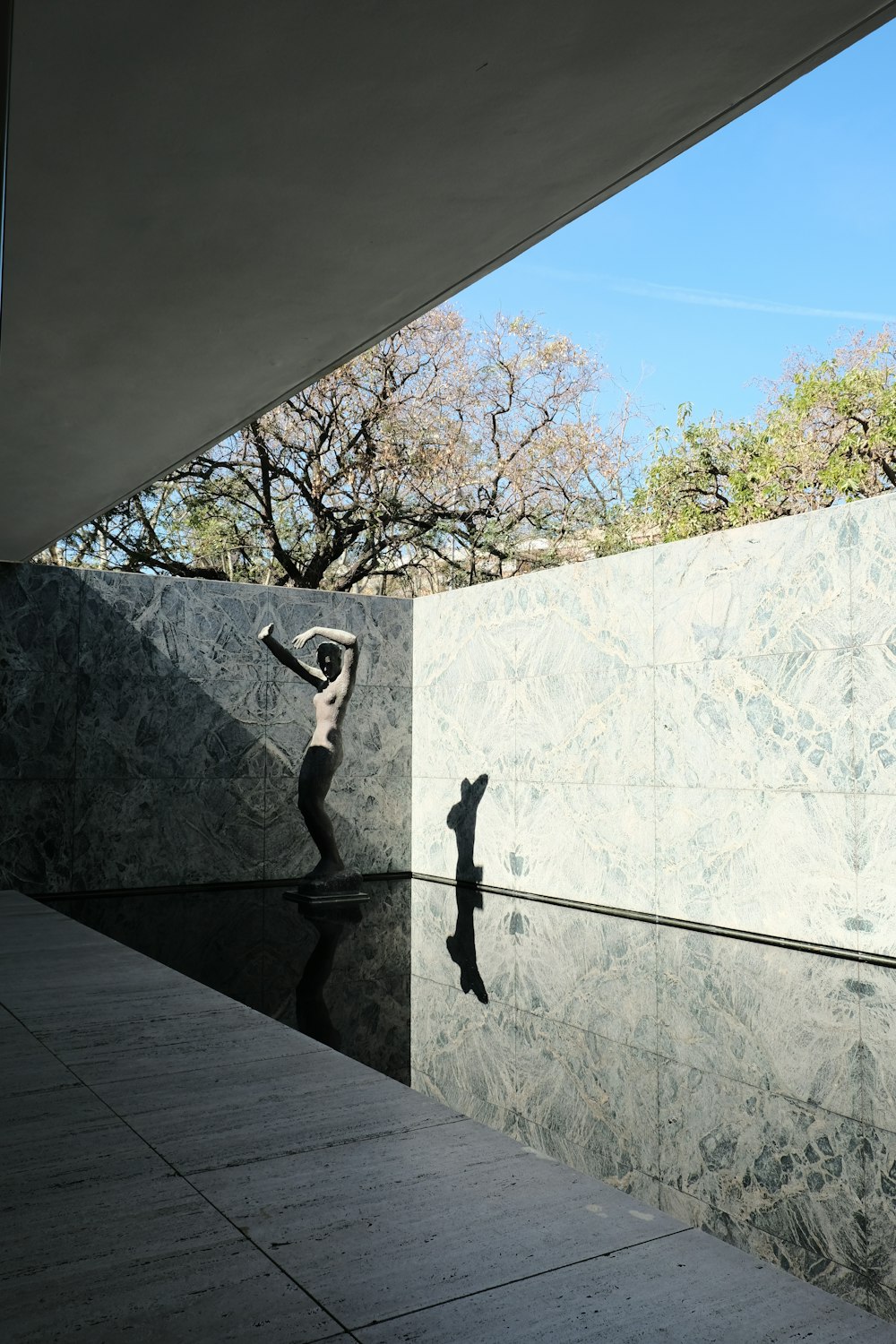 a statue of a person standing next to a wall