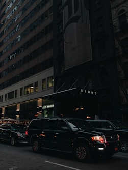 a city street filled with lots of traffic next to tall buildings