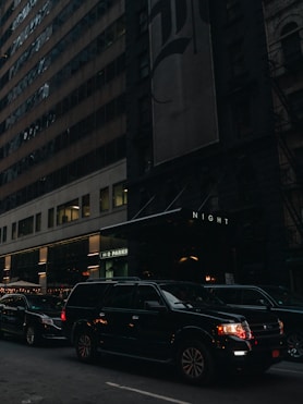a city street filled with lots of traffic next to tall buildings