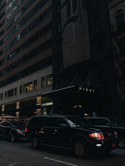 a city street filled with lots of traffic next to tall buildings