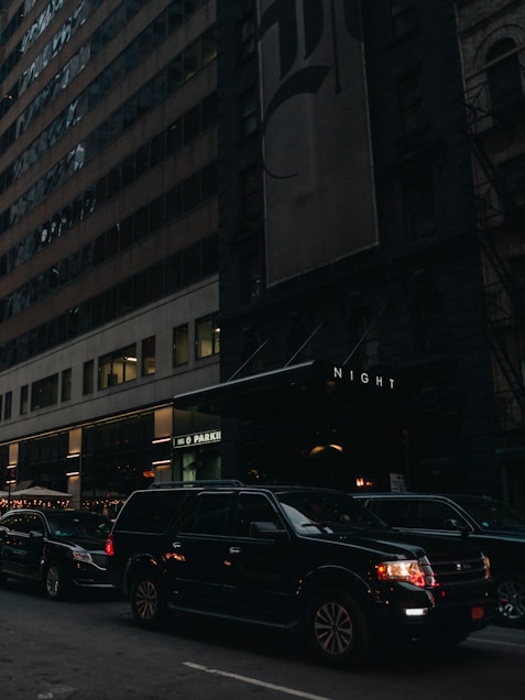 a city street filled with lots of traffic next to tall buildings