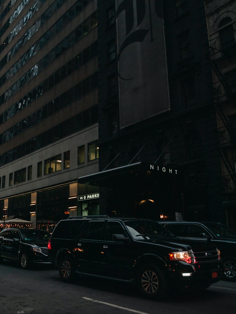 a city street filled with lots of traffic next to tall buildings