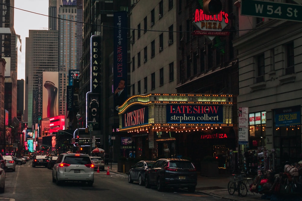 a city street filled with lots of traffic next to tall buildings