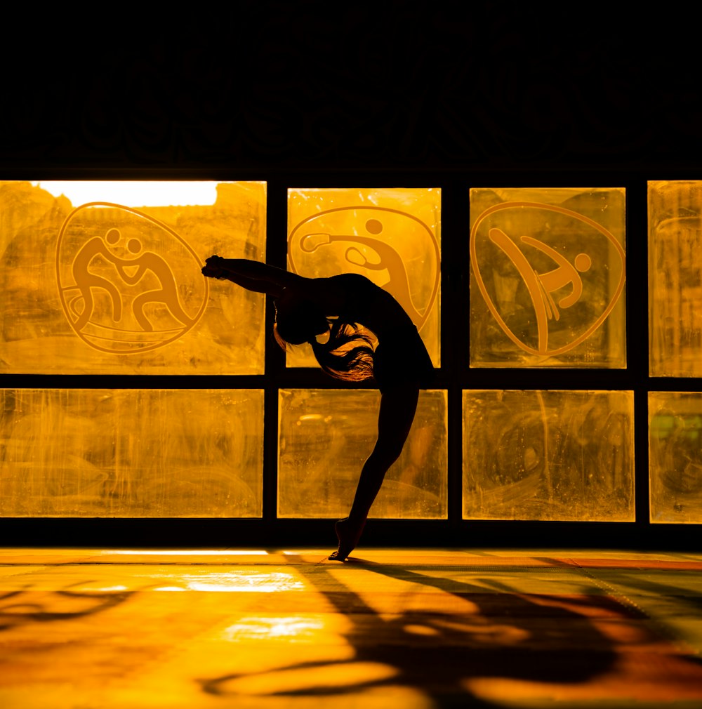 a person doing a trick on a skateboard in front of a window