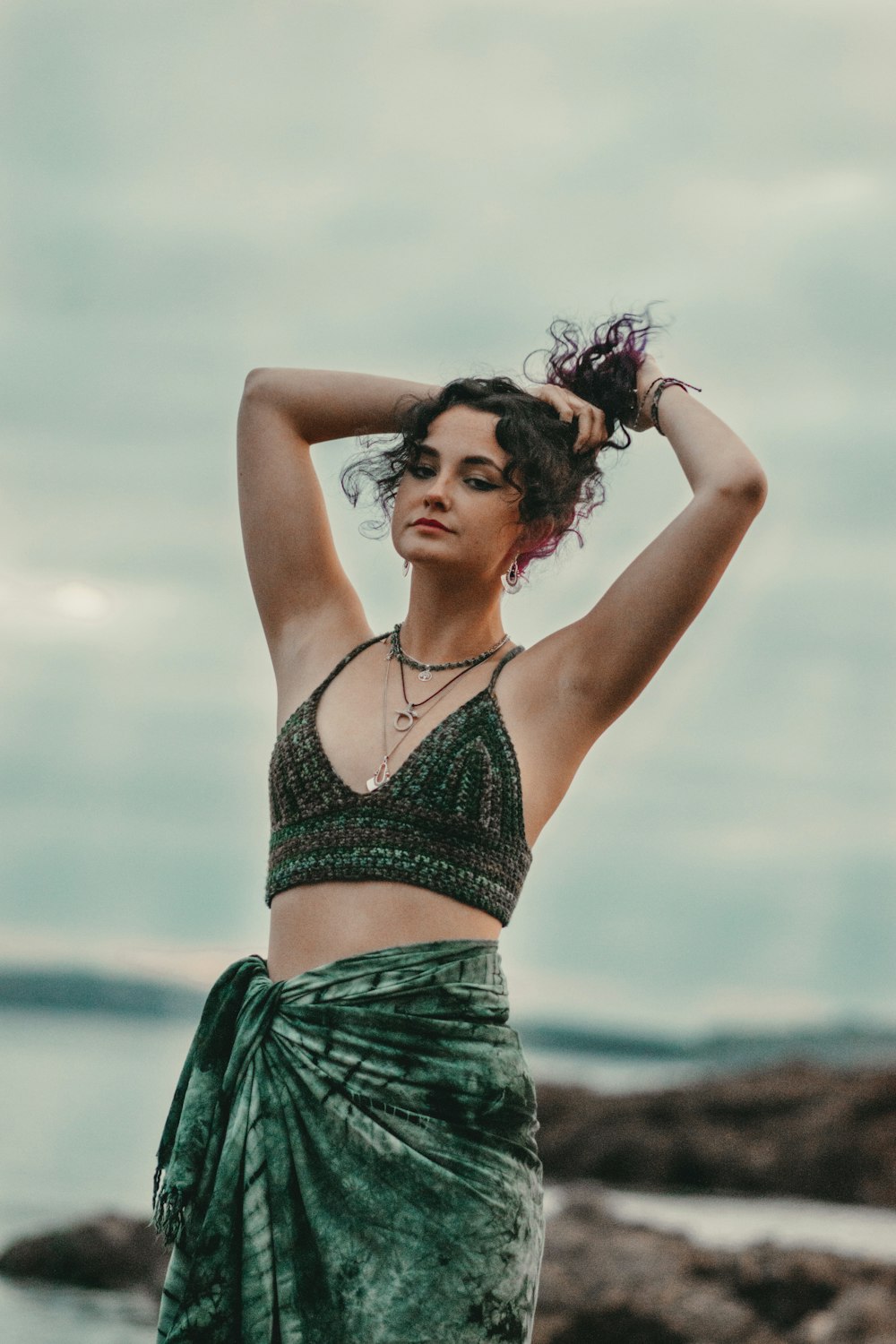 a woman in a green dress standing on a beach