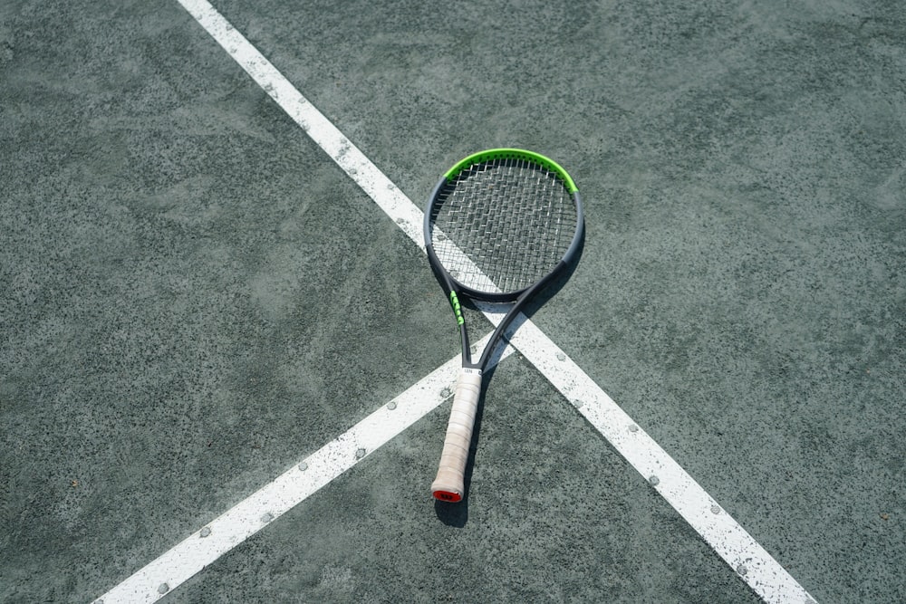 a tennis racket laying on a tennis court