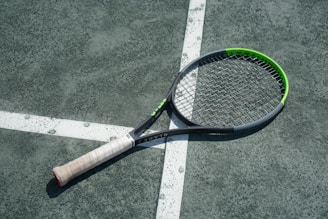 a tennis racket laying on a tennis court