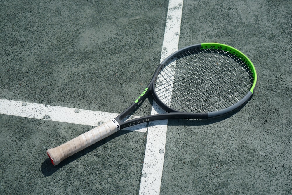 a tennis racket laying on a tennis court