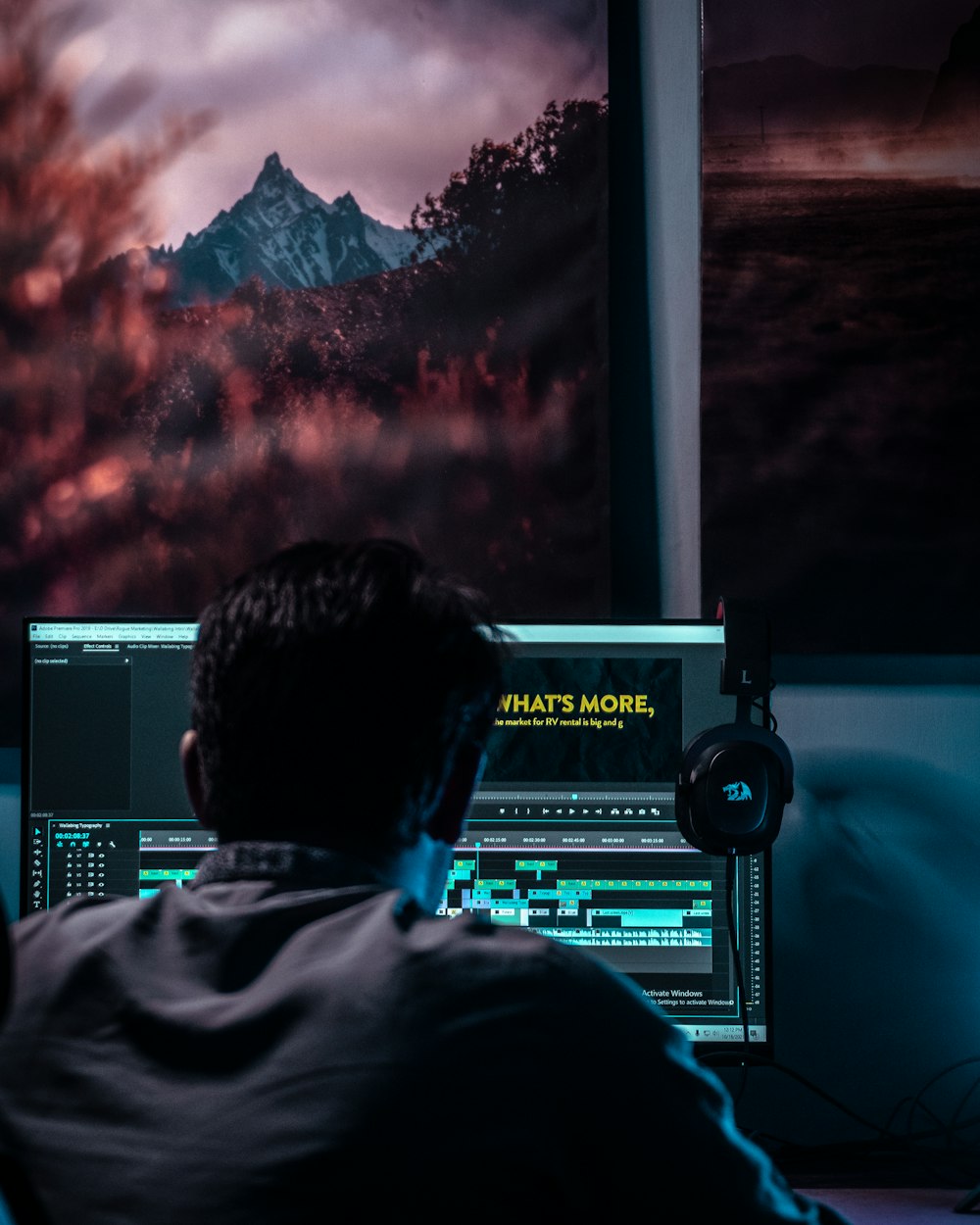 um homem sentado na frente de um monitor de computador