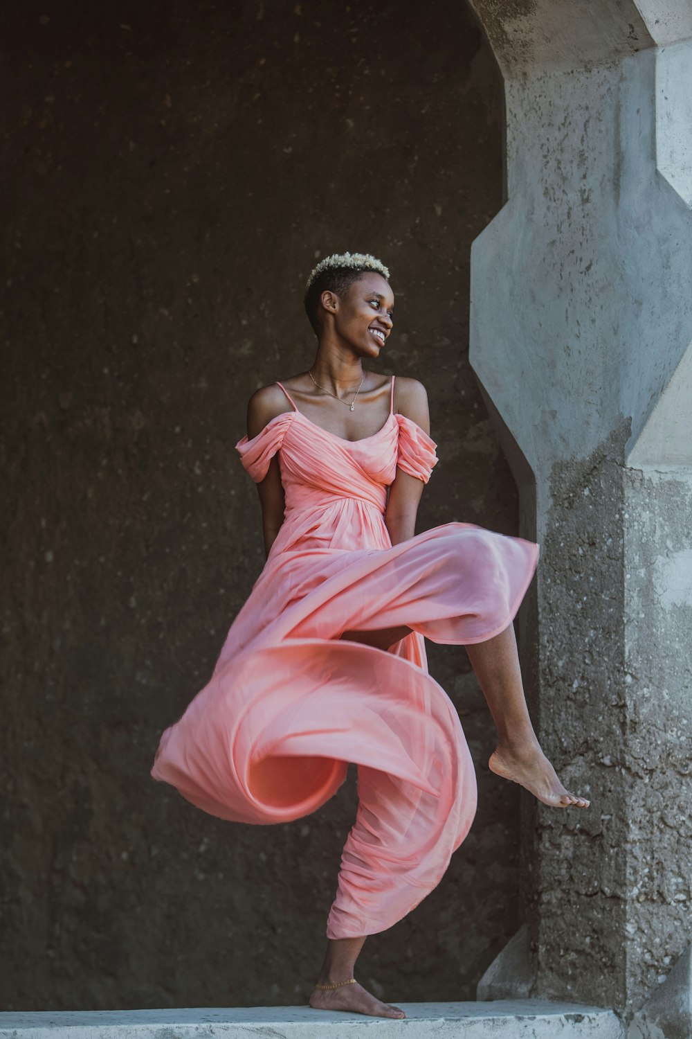 a woman in a pink dress is dancing