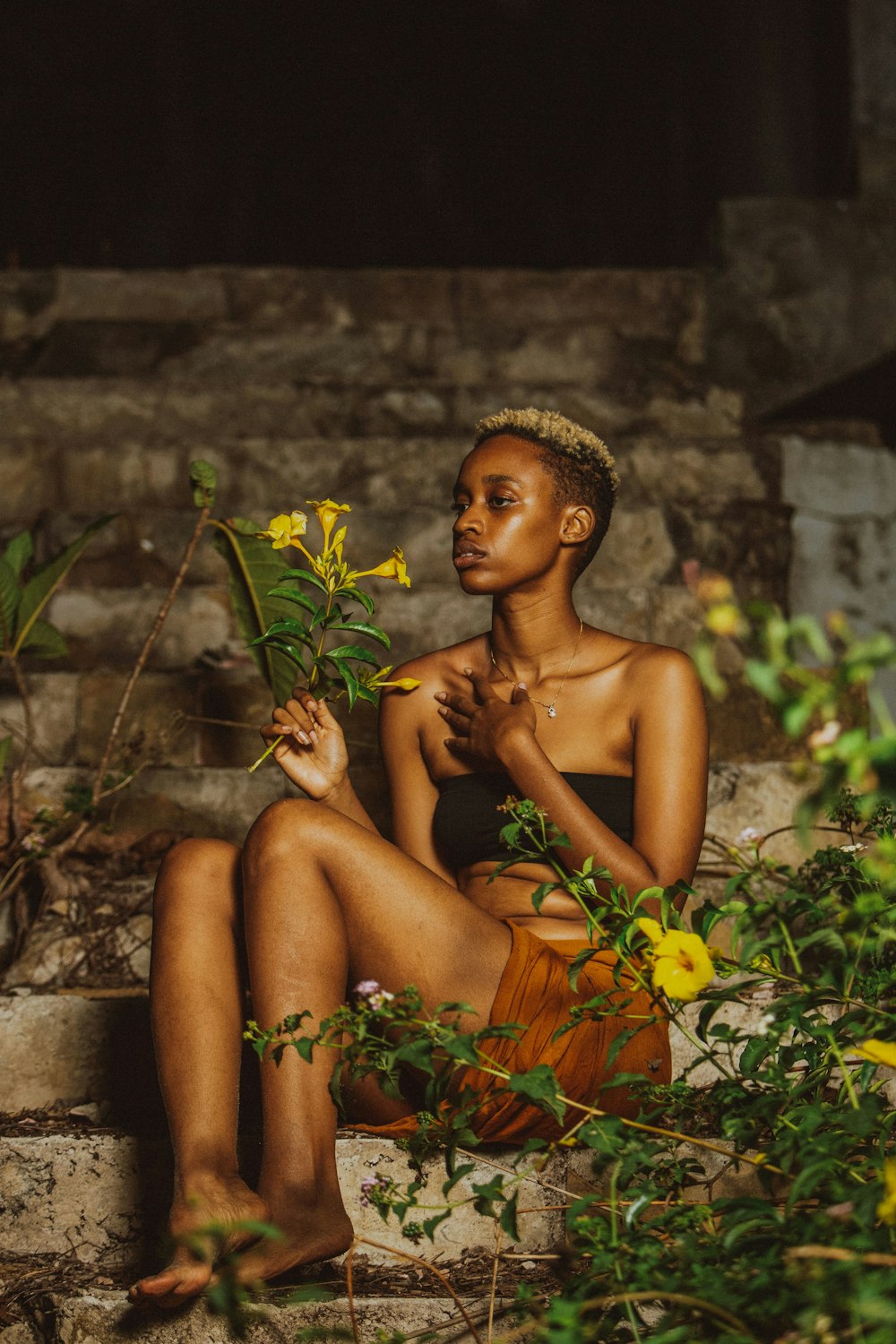 a woman sitting on steps with flowers in her hand